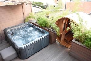 a hot tub on a deck with plants at Suite 40 Jacuzzi & Sauna by Malmedreams in Malmedy