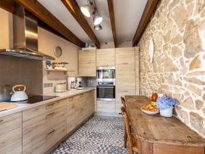 a kitchen with a wooden table and a stone wall at Maisons de la Clarté - Cottage Mer in Perros-Guirec