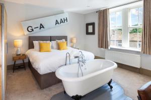 a bedroom with a bed and a bath tub next to a bed at The Craven Heifer Addingham in Addingham