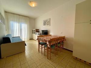 a room with a table and chairs and a kitchen at Apartment for five with balcony in Porto Santa Margherita di Caorle