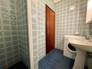 a bathroom with a sink and a washing machine at Apartment for five with balcony in Porto Santa Margherita di Caorle +12 photos
