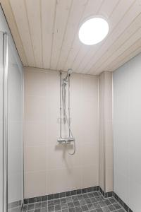 a shower in a room with white walls at Staycation Törrö Terveyssisar as 1 in Pudasjärvi