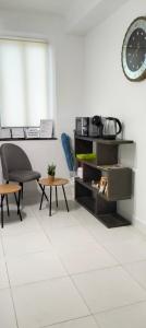 アリカンテにあるPensión La Marinaのテーブル、椅子、時計が備わる客室です。