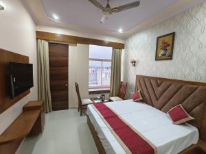 a hotel room with a bed and a television at Hotel Narayan Vilas , Jaipur in Jaipur +17 photos