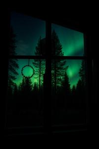 a window with a view of a green sky with trees at Villa Arctic Trail B - Lapland Escape with Outdoor Hot Tub & Ylläs Ski Passes in Äkäslompolo