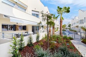 a view of the side of a building with palm trees at Villa Amalia 25 Phase II in Torrevieja