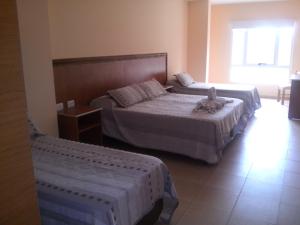 Un dormitorio con dos camas y una ventana. en Hotel Mónaco, en Villa Carlos Paz 26 fotos más