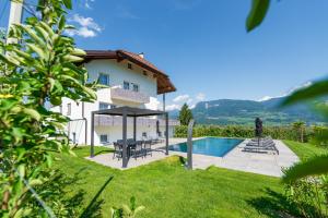 a villa with a swimming pool and a house at Ferienwohnungen Zwerger Reinhold in Termeno
