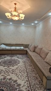 1 sofá grande en una sala de estar con alfombra en IVA guest House, en Karakol