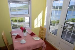 a table with a pink table cloth and flowers on it at Cottage Heights B&B in Castletownbere