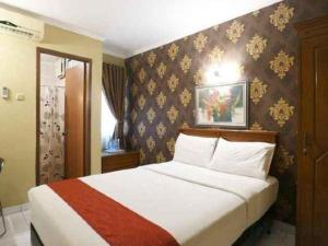 a bedroom with a large bed in a room at Hotel Permata Bandara in Gombolpaya +56 photos