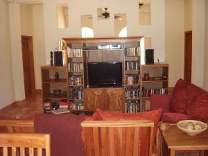 sala de estar con sofá y TV de pantalla plana en Serenity Sands en Corozal