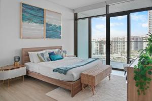 a bedroom with a large bed and large windows at Palace Residence Chic 2BR Creek Beach View in Dubai +9 photos