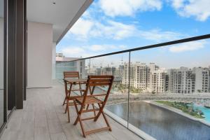a balcony with two chairs and a table with a view at Palace Residence Chic 2BR Creek Beach View in Dubai