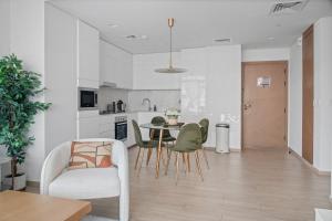 a kitchen and living room with a table and chairs at Palace Residence Chic 2BR Creek Beach View in Dubai