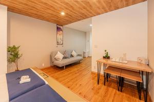 a room with a bed and a table and a couch at 桜の川70-7 初台駅1分 2-8人丨1 minute from Hatsudai 2-8 people in Tokyo