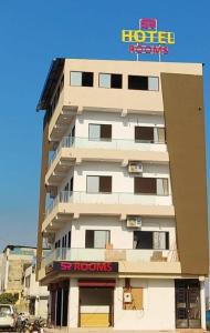 a tall white building with a sign on it at S R Hotel in Jāmb