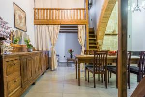a dining room with a table and chairs and a staircase at To Kamariko in Soroni