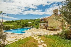an external view of a house with a swimming pool at Ivanini secluded stone Villa with a stunning view in Brseč