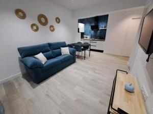 a living room with a blue couch and a table at ACC Vergara centro Parking cercano in Jaén