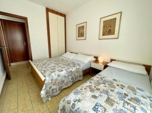 a hotel room with two beds and a window at Flat with balcony 370mt from the sea in Caorle