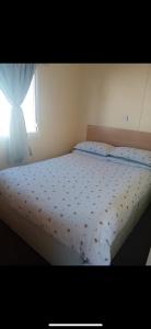 a bed in a bedroom with a window at Seawick Staycay in Saint Osyth