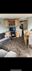 a living room with a couch and a table at Seawick Staycay in Saint Osyth