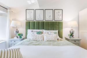 a bedroom with a white bed with a green headboard at Villa Podere Falcione in San Quirico di Moriano +52 photos