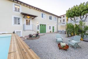 a courtyard with chairs and a swimming pool at Villa Podere Falcione in San Quirico di Moriano