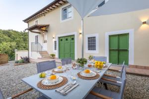 a table with plates of food on it in front of a house at Villa Podere Falcione in San Quirico di Moriano