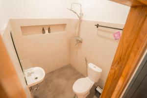 a small bathroom with a toilet and a sink at Yoki's Bungalows in Kuta Lombok