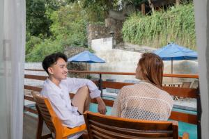 a man and a woman sitting at a table at Yoki's Bungalows in Kuta Lombok