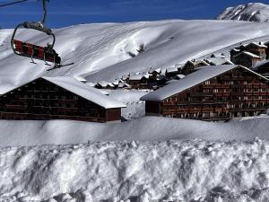 un lodge de ski dans la neige avec une remontée mécanique dans l'établissement Pied des Pistes, à La Plagne