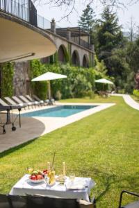 a table with a plate of fruit on it next to a pool at Les Planes de Viladrau in Viladrau