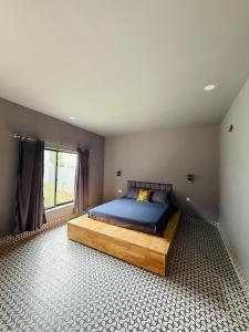 a bedroom with a bed with blue sheets and a window at Angkor Piseth Retreat in Phumi Ta Phul +23 photos