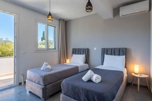 Dos camas en una habitación con ventana. en Starry Sky Luxury Apartment 6, en Áno Lefkímmi
