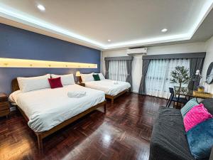 a hotel room with two beds and a couch at SPACIOUS, 3 mins walking to BTS Phra Khanong & Near Thonglo, Em District, Terminal 21, MAX 20 People in Bangkok