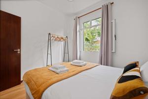a bedroom with a large bed with two towels on it at Villa Por do Sol in Relógio do Poiso