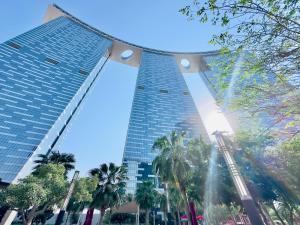 a tall building with palm trees in front of it at Urban Oasis 1BR Apartment in Gate Towers in Abu Dhabi