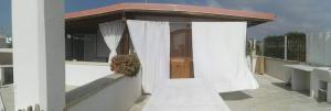 a balcony with a white curtain and a door at Case vacanza La Rondine in Alliste