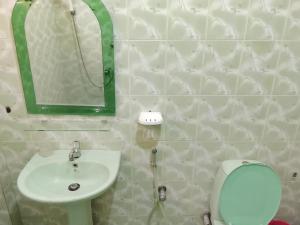 阿努拉德普勒Ranmini Family Resort的浴室里有洗手池、马桶和镜子。 更多6张照片