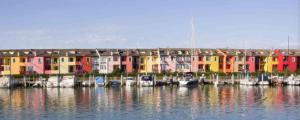a row of colorful houses with boats in the water at Cozy flat with balcony in Caorle +13 photos