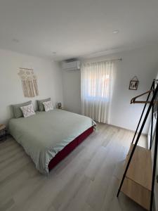 a white bedroom with a large bed and a staircase at Montesinhos in Nisa