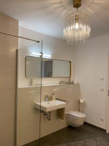 La salle de bains est pourvue d'un lavabo, de toilettes et d'un lustre. dans l'établissement bei Stefanie, à Bad Kötzting
