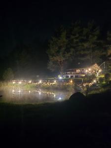 a house at night with lights on a lake at Hõbesoo Puhkekeskus in Lepiku