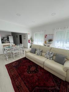 a living room with a white couch and a red rug at Montesinhos in Nisa