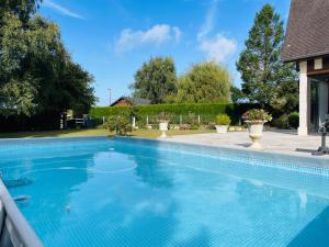 une piscine avec de l'eau bleue dans une cour dans l'établissement Gîte normand climatisé avec piscine privée, à Condé-sur-Seulles