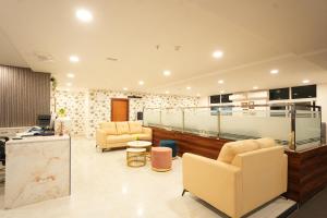 a lobby with two chairs and a reception desk at Elite Hotel HITECH in Hyderabad