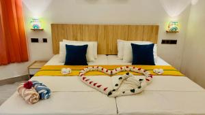 a bedroom with two beds with a heart shaped pillow at Dream Inn at Thulusdhoo in Thulusdhoo