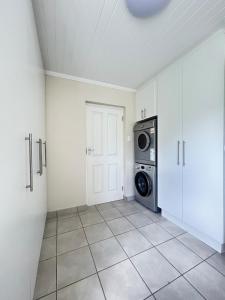 a laundry room with a washer and dryer at Ebb & Flow Beach House in Oyster Bay